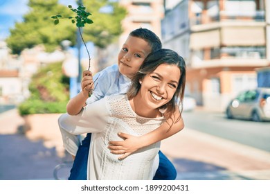 Adorable mother and son smiling happy on piggyback at the city.
