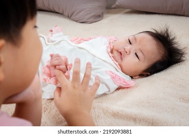 Adorable Newborn Baby Playing In Bed After Waking Up With Older Brother To Play With. By Reaching Out To Touch His Brother's Finger With Warmth And Teasing Younger While Mom Went To Make Milk To Eat.