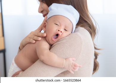 Adorable Newborn Baby Yawn Sleepy Or Cry On Mom Shoulder, Young Asian Beautiful Mother Hold  Infant 0-1 Month With Love, Gently, Happy Sleeping Trust Safe With Mom Hug, Healthy Newborn Baby Concept