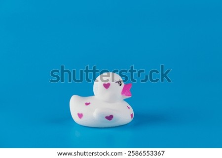 Adorable Rubber Duck with Heart Patterns on a Vibrant Blue Background: A Charming Addition to the Bathroom or Playroom Decor That Brings Joy and Fun to Any Setting