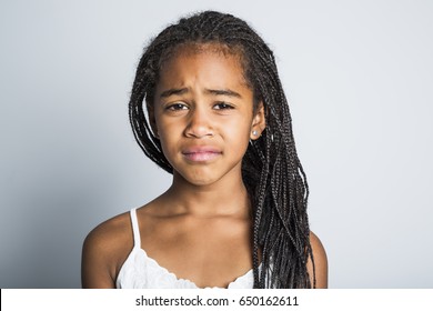 An Adorable Sad African Little Girl On Studio Gray Background