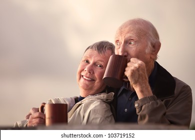 Adorable senior couple outdoors drinking from mugs - Powered by Shutterstock