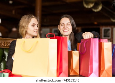 Adorable Smiling Girls Having A Sneak Peek On Gift Bags