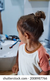 An Adorable Spanish Baby Girl Washing Her Teeth In The Bathroom