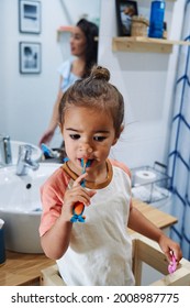 An Adorable Spanish Baby Girl Washing Her Teeth In The Bathroom