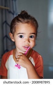 An Adorable Spanish Baby Girl Washing Her Teeth In The Bathroom