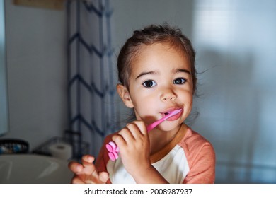 An Adorable Spanish Baby Girl Washing Her Teeth In The Bathroom