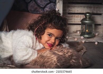 An Adorable Spanish Girl Lying On A Furry Pillow While Looking At The Camera