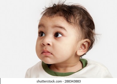 Adorable Surprised Indian Baby Boy Looking Over Gray Background