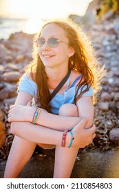 Adorable teenage girl outdoors enjoying sunset at beach on summer day