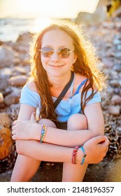 Adorable teenage girl outdoors enjoying sunset at beach on summer day