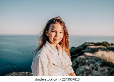 Adorable teenage girl outdoors enjoying sunset at beach on summer day. Close up portrait of smiling young romantic teenager girl with long hair on beach at summer evening. Travel and holidays - Powered by Shutterstock