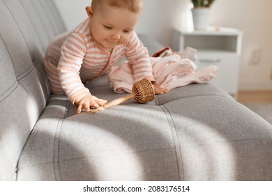 Adorable Toddler Baby Girl Having Fun Alone At Home, Posing In Sunlight, Playing With Wooden Toy And Clothing, Crawling With Curious Facial Expression, Exploring World Around.