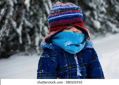adorable toddler boy cold sitting in snow on winter day