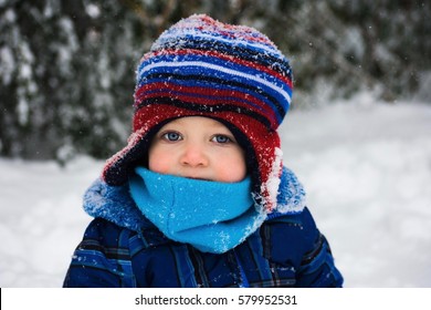 adorable toddler boy sitting in snow during winter