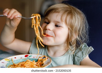 Adorable Toddler Girl Eat Pasta Spaghetti With Tomato Bolognese With Minced Meat. Happy Preschool Child Eating Fresh Cooked Healthy Meal With Noodles And Vegetables At Home, Indoors.