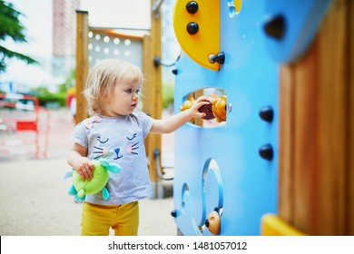 Adorable Toddler Girl Having Fun On Playground. Outdoor Activities For Kids