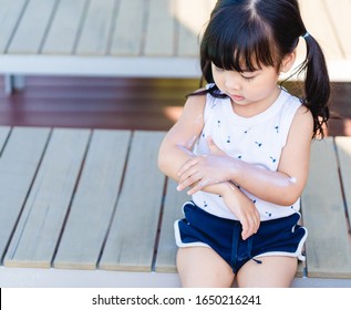 Adorable toddler girl putting solar cream on arms hands Smiling happy outdoors by pool under sunshine on beautiful summer day.Mixed race Asian / Caucasian kid girl.Sunscreen or sunblock and Skincare. - Powered by Shutterstock