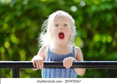 Adorable Toddler Girl Screaming, Singing And Making Funny Faces Outdoors At Summer