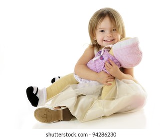 An Adorable Toddler Happily Hugging Her Baby Doll.  On A White Background.