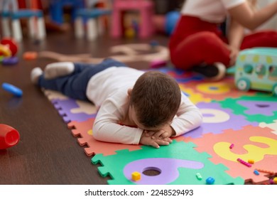Adorable toddler lying on floor crying at kindergarten - Shutterstock ID 2248529493
