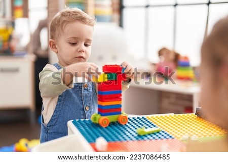 Adorable toddler playing with construction blocks standing at kindergarten Photo stock © 