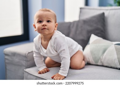 Adorable Toddler Sitting On Sofa At Home