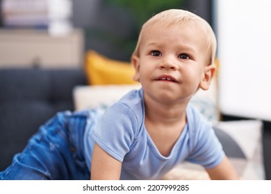 Adorable Toddler Sitting On Sofa With Relaxed Expression At Home