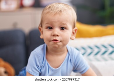 Adorable Toddler Sitting On Sofa With Relaxed Expression At Home