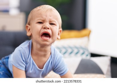 Adorable Toddler Sitting On Sofa Crying At Home