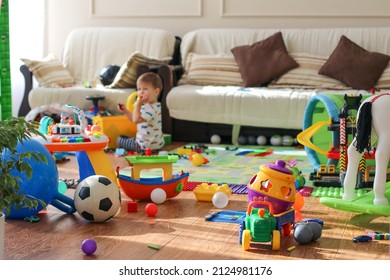 Adorable toddlers playing among the many toys at home. A mess in the children's room, a lot of toys in the children's room. Dirty house. Children's room - Shutterstock ID 2124981176