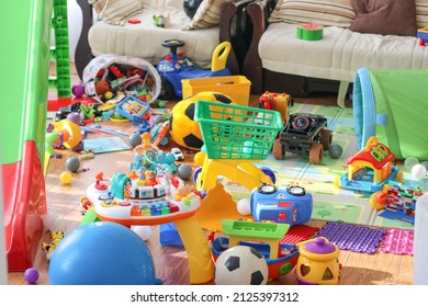 Adorable toddlers playing among the many toys at home. A mess in the children's room, a lot of toys in the children's room. Dirty house. Children's room. Selective focus  - Shutterstock ID 2125397312