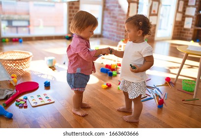 Adorable Toddlers Playing Around Lots Of Toys At Kindergarten