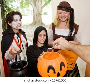 Adorable Trick Or Treaters In The Doorway Waiting For Candy.