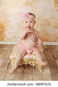 Adorable Young Baby Girl Wearing A Vintage Pearl Necklace And Pink Rose Headband