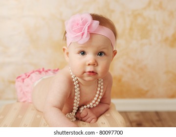 Adorable Young Baby Girl Wearing A Vintage Pearl Necklace And Pink Rose Headband