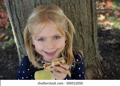 Adorable Young Girl Eating Peanut Butter Sandwich