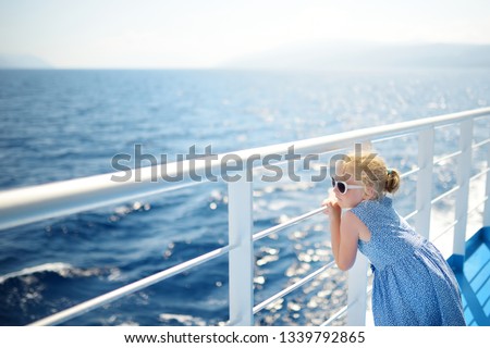 Adorable young girl enjoying ferry ride staring at the deep blue sea. Child having fun on summer family vacation in Greece. Kid sailing on a boat.