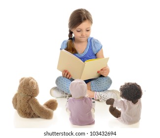 An adorable young "teacher" reading a book to her toy students.  On a white background. - Powered by Shutterstock