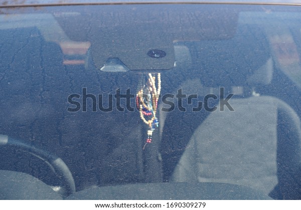 Adornments hanging from a\
mirror in a car