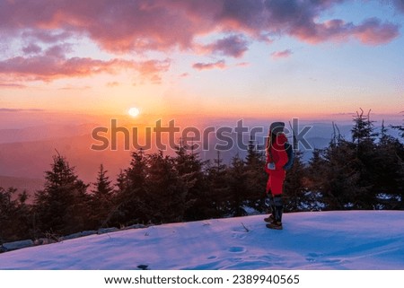 Adult adventurous woman standing on top of a snow peak. Winter Wonderland. . Aerial landscape from Beskydy mountain, Czech republic. Lysa mounta