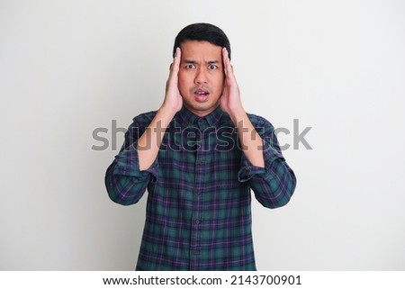 Adult Asian man cover both side of his face with hand