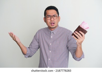 Adult Asian Man Holding Wallet With Money Inside And Showing Confused Expression