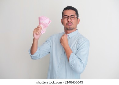 Adult Asian Man Showing Arrogant Face Expression While Holding Paper Money