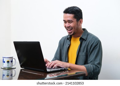 Adult Asian Man Showing Excited Expression When Typing On His Laptop