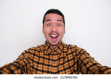 Adult Asian man showing excited face expression when taking a selfie