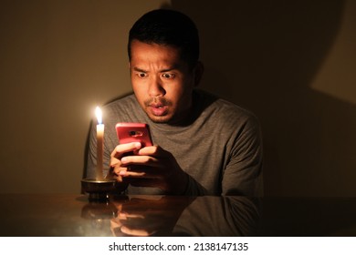 Adult Asian Man Showing Panic Expression When Trying To Call For Emergency During Electricity Power Failure