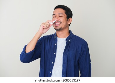 Adult Asian Man Showing Relieved Expression When Using Nasal Stick Inhaler