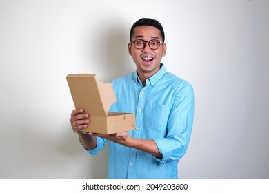 Adult Asian Man Showing Surprised Face Expression When Open A Gift Box