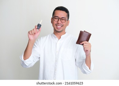 Adult Asian man smiling confident while showing his wallet and car key - Powered by Shutterstock